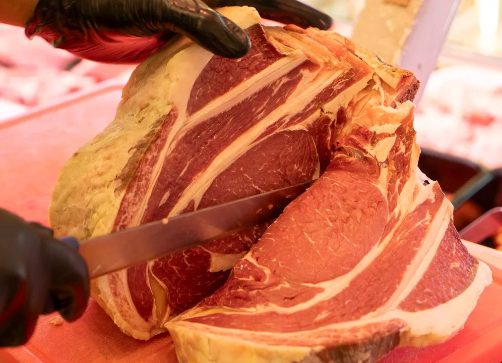 Un taglio di manzo marezzato affettato a mano al banco della macelleria